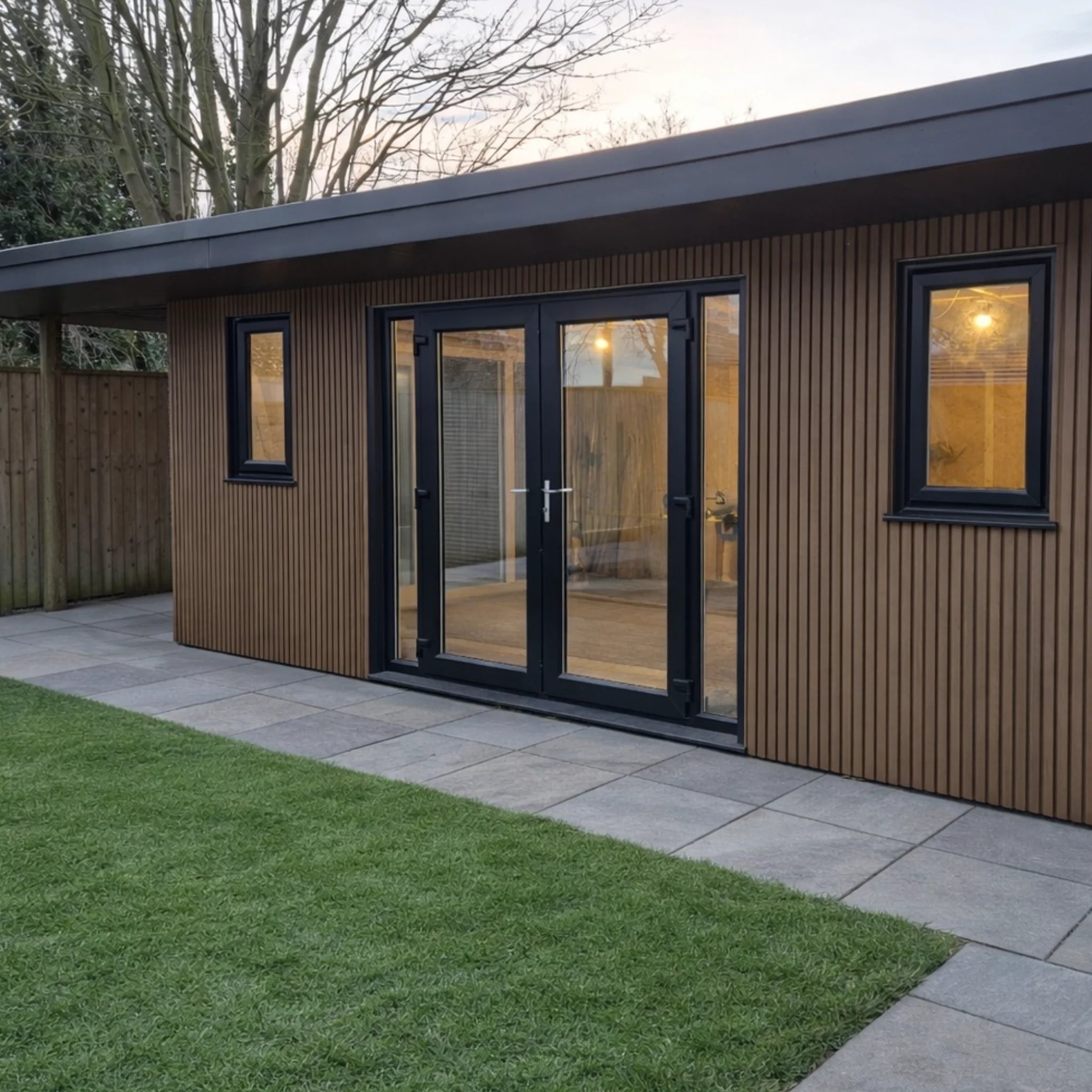 teak co-extrusion composite cladding on a garden room with grass