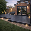 Backyard with wooden deck, hot tub, and brick house exterior.
