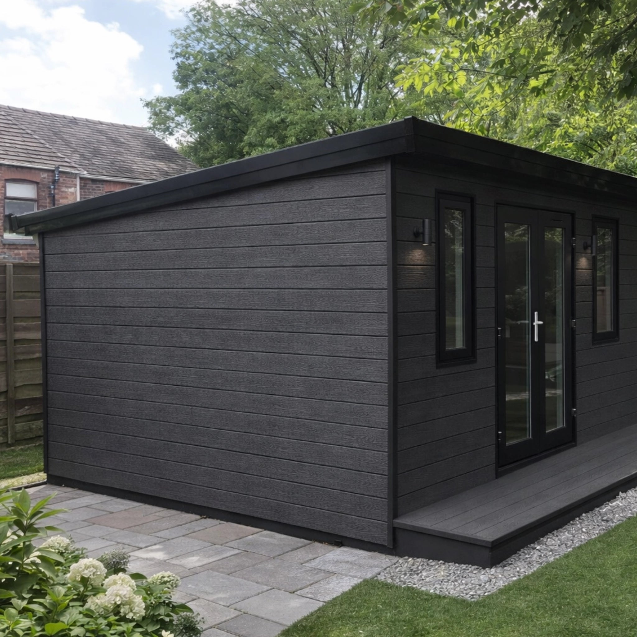 ancient black composite cladding garden shed with a door and windows in a backyard setting.