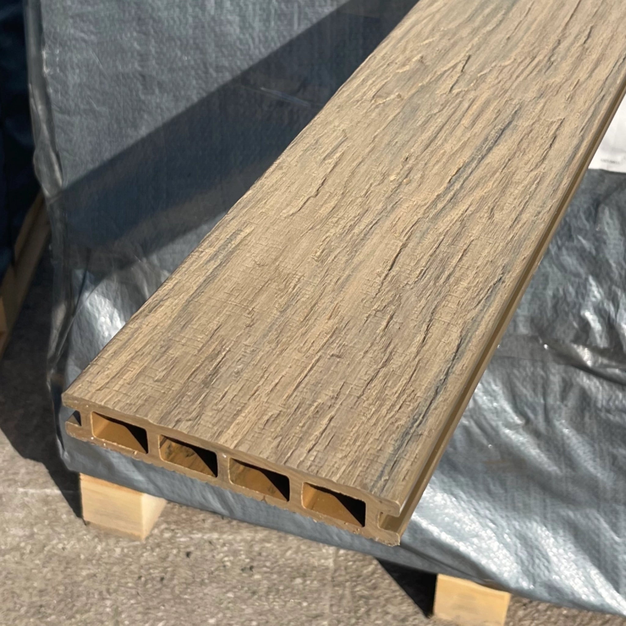 composite beige deck board on a gray tarp