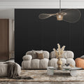 Modern living room with a beige sofa, coffee table, and decorative elements against a black oak acoustic wall panel wall