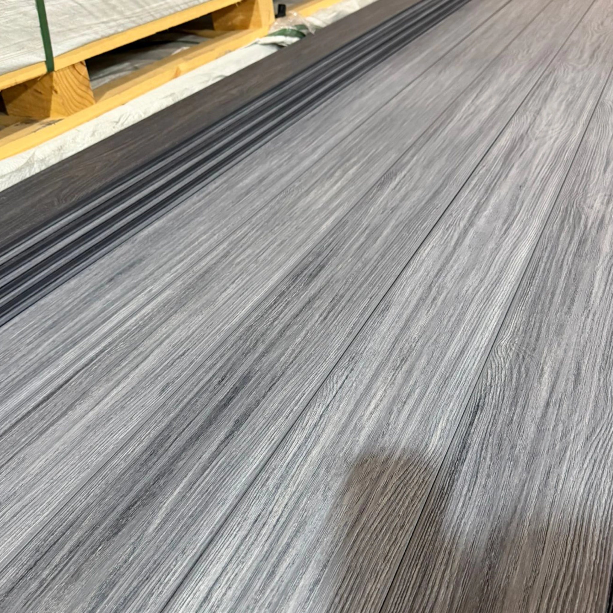 grey premium dual-capped composite decking boards row on pallet