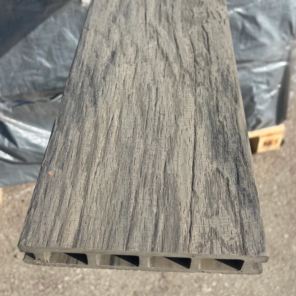 composite deck board with a textured surface on a concrete floor.