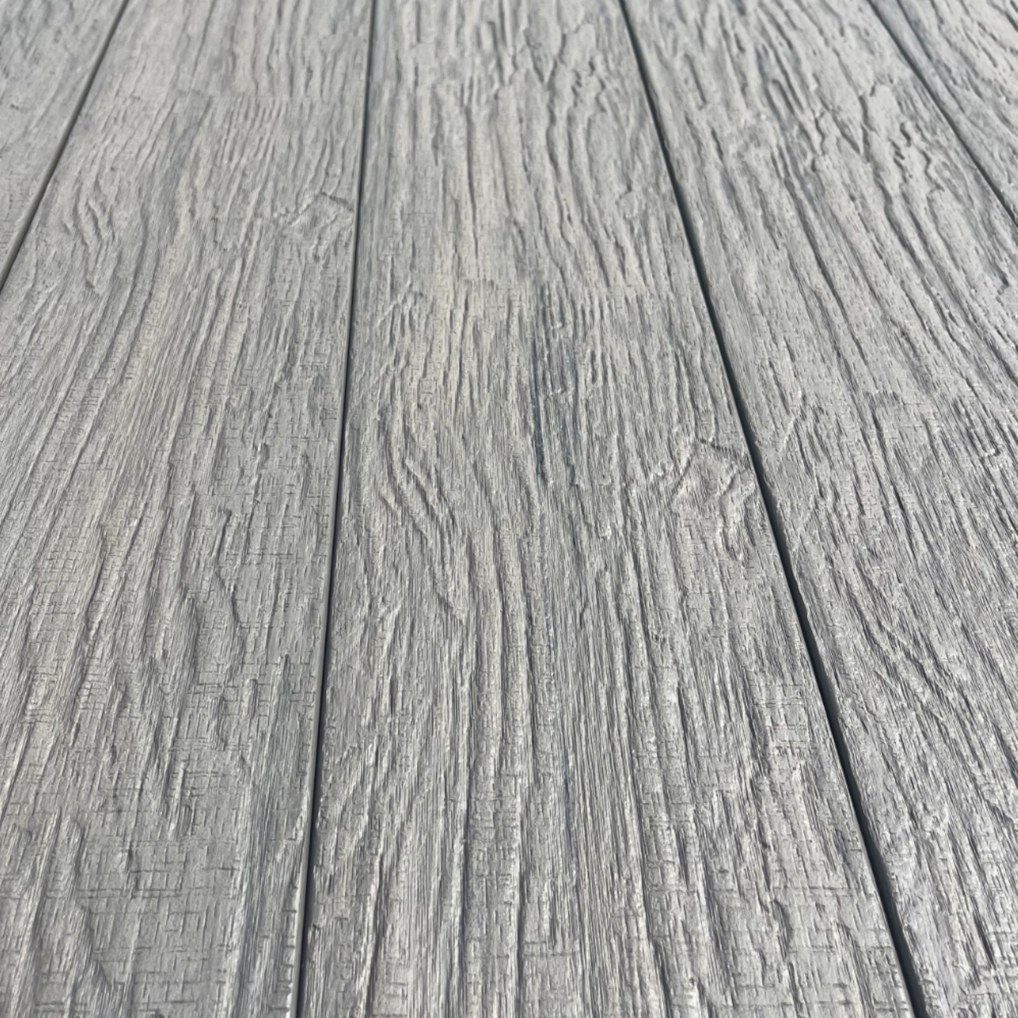Close-up of gray composite decking planks with a textured surface