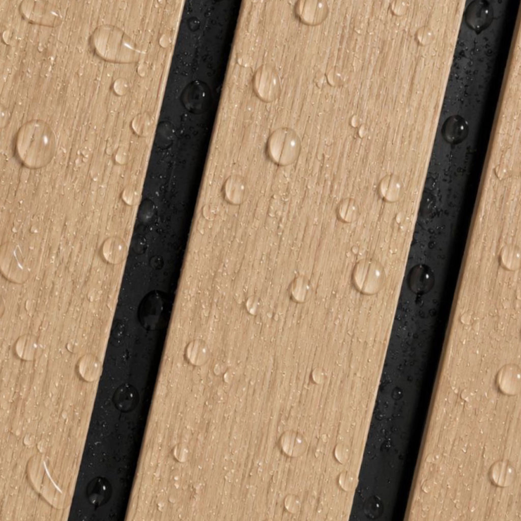 Close-up of a wood-look surface with diagonal planks in light tan and black, covered with water droplets.