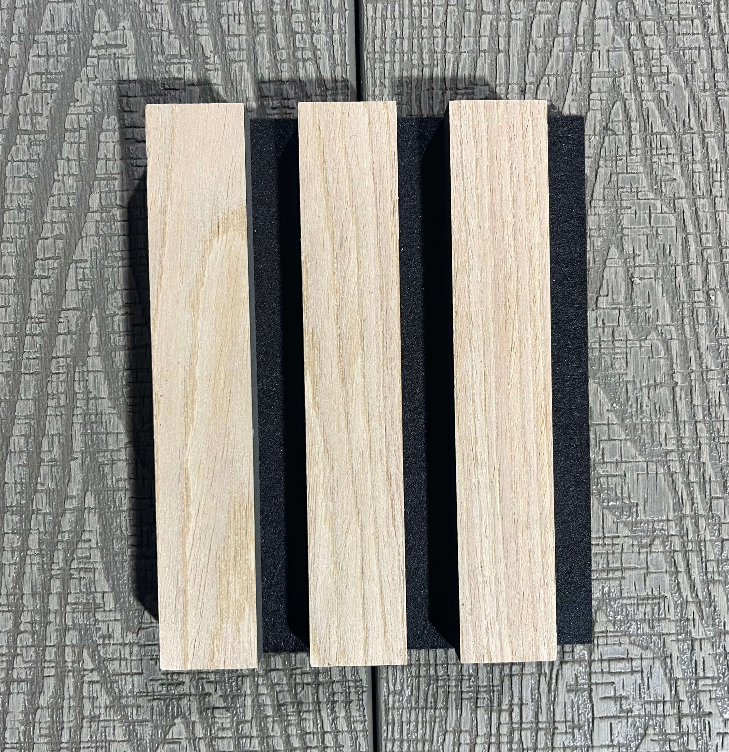Wooden slats with black separators on a textured gray background