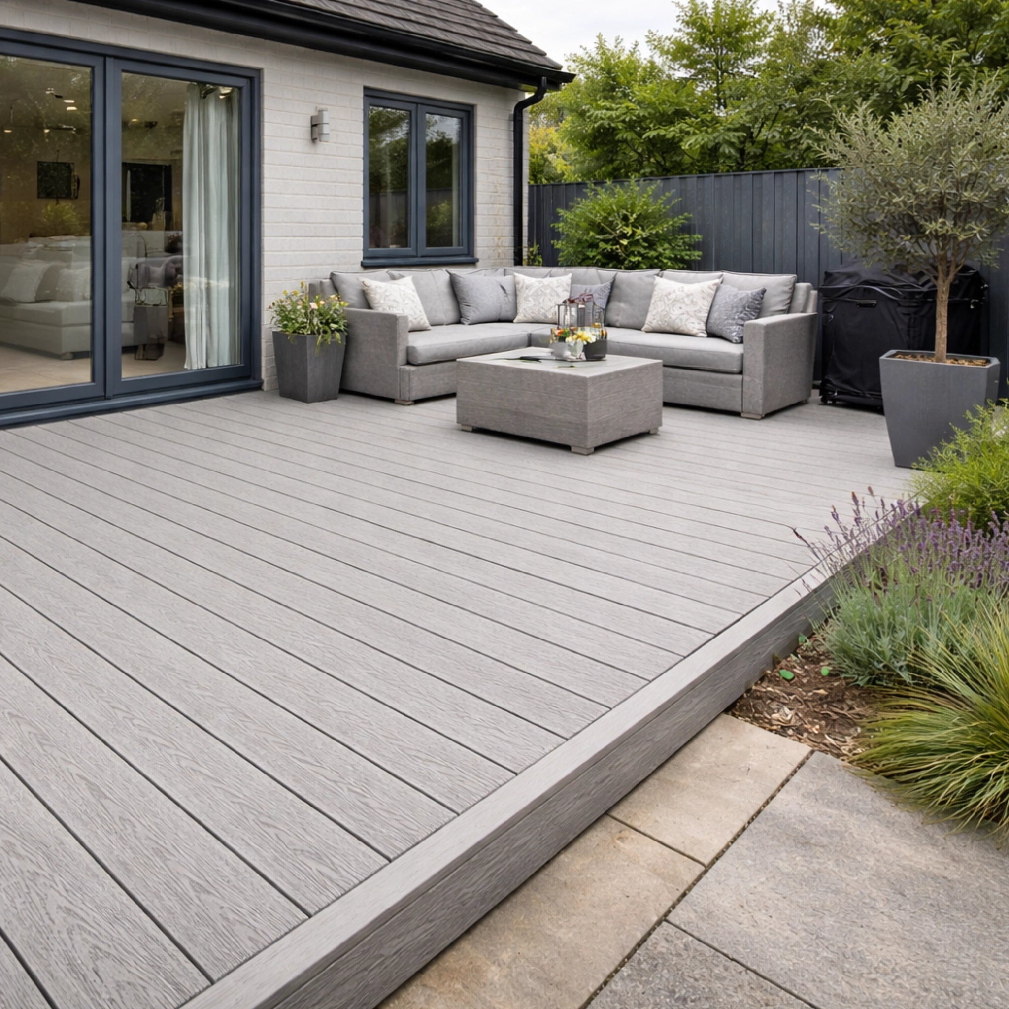 Outdoor patio with salt lake silver deck, sectional sofa, and potted plants.