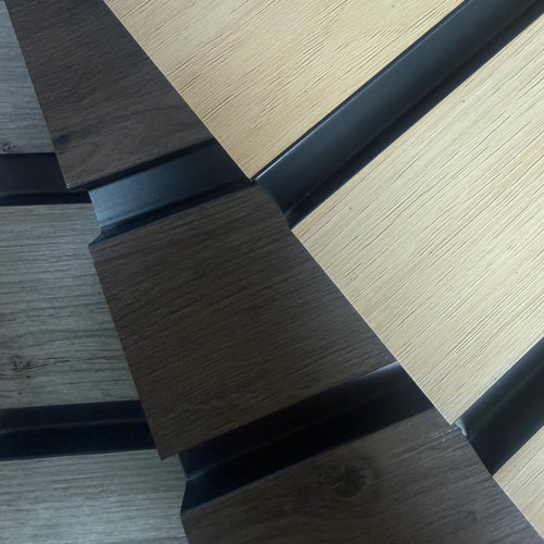 Close-up of interlocking aqua slat samples in dark brown and light oak tones with black metal or trim sections between them.