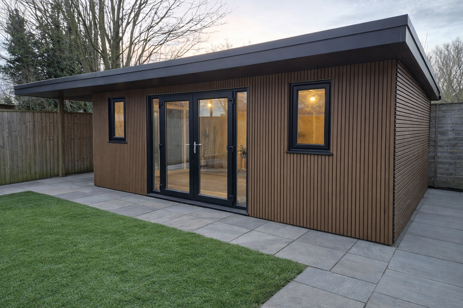 Modern shed with composite cladding and glass doors in a garden setting