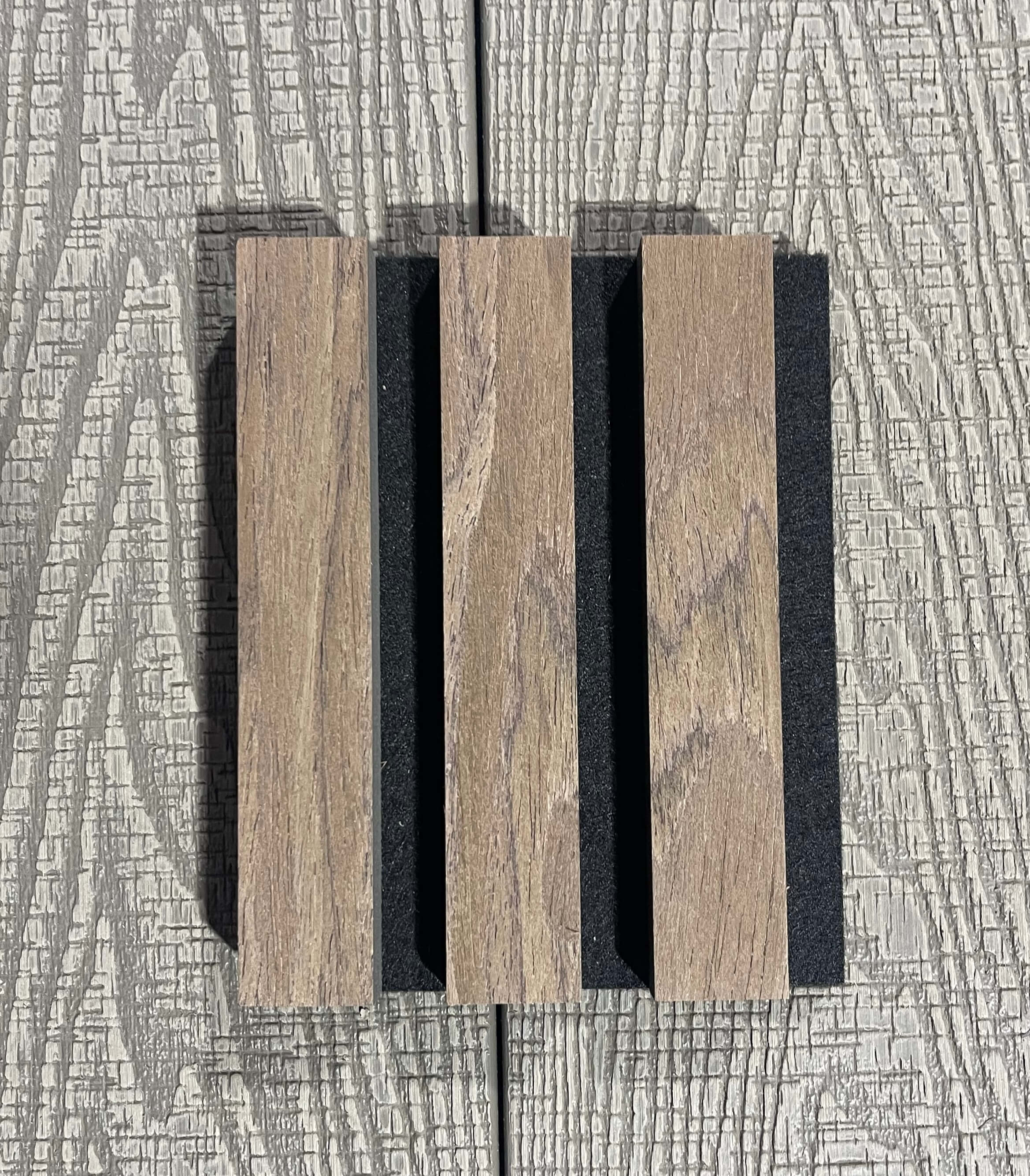 Wooden slats with black separators on a textured gray background