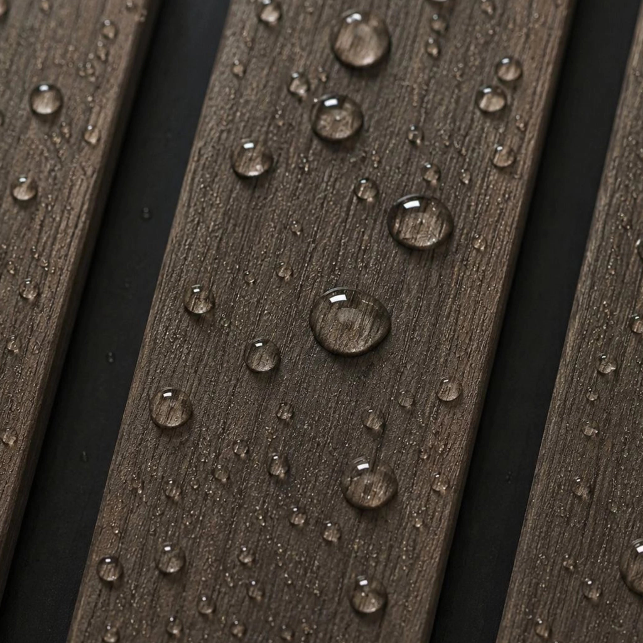 Close-up of dark brown textured wood-look slats with water droplets on a black background.