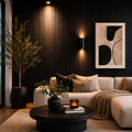 Modern living room with a beige sofa, round coffee table, and decorative elements. Charcoal line stone Flexistone Veneer feature wall.