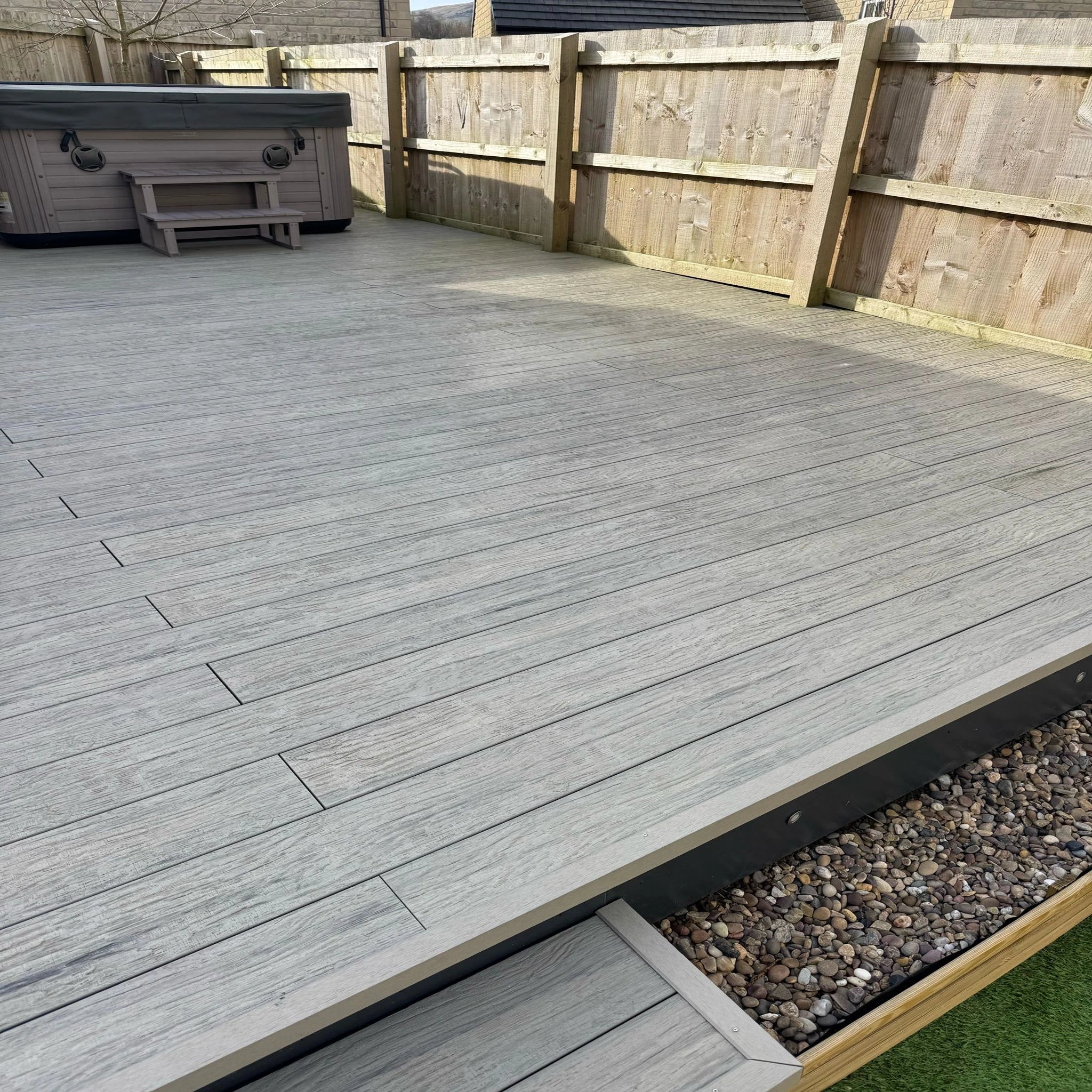 grey driftwood composite deck with a hot tub in the background