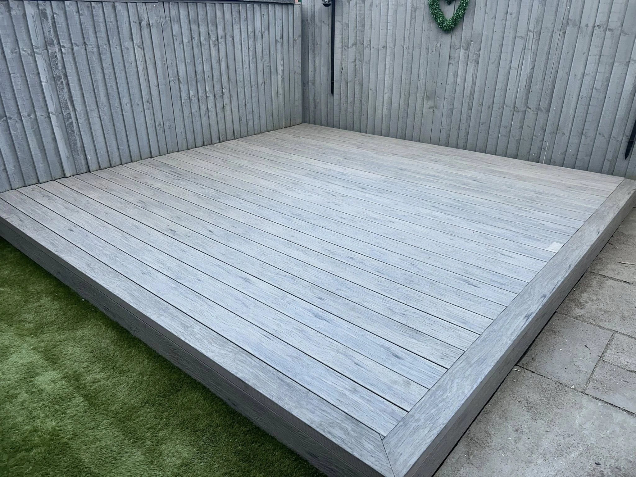 grey driftwood decking in a garden setting with lawn