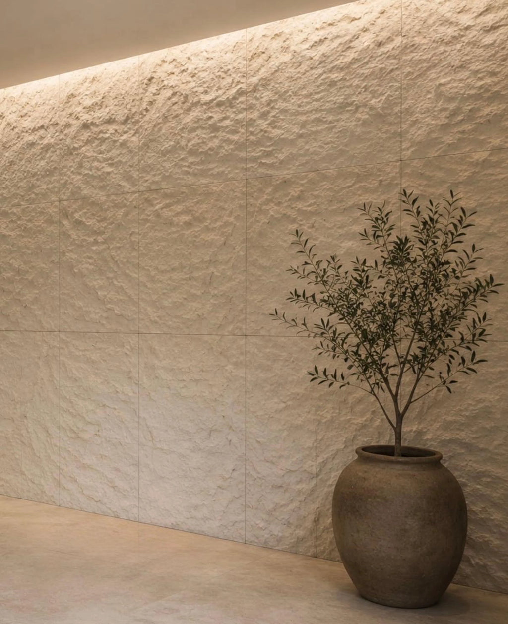 flexistone off white rough granite wall with a decorative vase in a modern interior setting.
